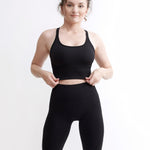 Set Original by Gymtuned în negru – bustieră sport pentru fitness si sala și colanți modelatori seamless fără cusături, purtate de model.