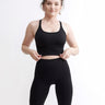Set Original by Gymtuned în negru – bustieră sport pentru fitness si sala și colanți modelatori seamless fără cusături, purtate de model.